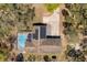 Birds-eye view of a home with a pool, solar panels, and a long driveway at 35128 Excalibur Rd, Webster, FL 33597