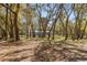 View of the private home exterior with a screened porch surrounded by mature trees at 35128 Excalibur Rd, Webster, FL 33597