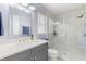 Modern bathroom featuring a glass enclosed shower and vanity with grey cabinets at 35128 Excalibur Rd, Webster, FL 33597