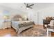 Spacious bedroom featuring hardwood floors, a ceiling fan, and a king-sized bed at 35128 Excalibur Rd, Webster, FL 33597