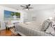 Bright bedroom featuring hardwood floors, a ceiling fan, and a large flat screen TV at 35128 Excalibur Rd, Webster, FL 33597