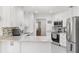 Bright kitchen featuring white cabinets, stainless steel appliances, and speckled countertops at 35128 Excalibur Rd, Webster, FL 33597