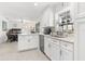 Bright kitchen with white cabinets, stainless steel appliances, and a breakfast bar overlooking the dining area at 35128 Excalibur Rd, Webster, FL 33597
