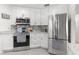Bright kitchen featuring white cabinets, stainless steel appliances, and stylish backsplash at 35128 Excalibur Rd, Webster, FL 33597