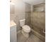 Neutral tiled bathroom featuring a tiled shower with a window and modern fixtures at 3603 Darlington Rd, Holiday, FL 34691