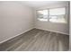 This is an empty bedroom with wood-look floors and a large window at 3603 Darlington Rd, Holiday, FL 34691