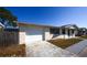 Side view of the home showcasing the attached garage, neutral color palette, and driveway at 3603 Darlington Rd, Holiday, FL 34691