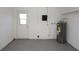 Functional garage area showcasing the water heater, electrical panel, and access to the exterior at 3603 Darlington Rd, Holiday, FL 34691