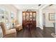 Living room featuring plantation shutters, dark hardwood floors, and elegant display cabinet at 4027 Benson N Ave, St Petersburg, FL 33713