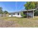 View of a quaint backyard with a small, screened-in porch adjacent to the white siding of the home at 4030 Marlin Se Dr, St Petersburg, FL 33705