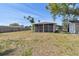 Backyard featuring a large screened porch and a storage shed against a wood fence at 4030 Marlin Se Dr, St Petersburg, FL 33705