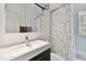 Well-lit bathroom featuring a modern vanity, floral shower curtain, and a glass block window for natural light at 4030 Marlin Se Dr, St Petersburg, FL 33705