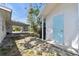 Side yard view with a carport, adjacent structure with a light blue door, and concrete brick features at 4030 Marlin Se Dr, St Petersburg, FL 33705