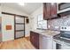 Updated kitchen features wood cabinets, mosaic backsplash, and a modern sliding barn door at 4030 Marlin Se Dr, St Petersburg, FL 33705