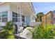 Cozy front porch features comfortable seating and lush tropical landscaping, creating a welcoming entrance at 4030 Marlin Se Dr, St Petersburg, FL 33705