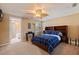 Inviting bedroom featuring a ceiling fan, natural light, and a wood bed frame with blue plaid bedding at 487 Pinellas Bayway S # 6, Tierra Verde, FL 33715