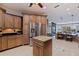 Spacious kitchen featuring custom wood cabinets, island with granite counters, and stainless-steel refrigerator at 487 Pinellas Bayway S # 6, Tierra Verde, FL 33715