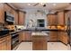 Charming kitchen with custom wood cabinetry, black granite counters, and stainless steel appliances at 487 Pinellas Bayway S # 6, Tierra Verde, FL 33715