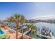 Beautiful waterfront view with a boat dock, pool, patio furniture, and swaying palm trees in a sunny setting at 487 Pinellas Bayway S # 6, Tierra Verde, FL 33715