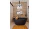 Luxurious bathroom featuring a modern black freestanding tub and wood accent wall at 487 Pinellas Bayway S # 6, Tierra Verde, FL 33715