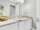 Bathroom with white cabinets, quartz countertop, and a decorative mirror at 4926 Pamplona Ct, Wimauma, FL 33598