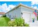 This home's side exterior features a well-maintained lawn, plants, and a two car garage at 4926 Pamplona Ct, Wimauma, FL 33598