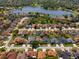 Aerial view of a residential neighborhood highlighting tree-lined streets, a pond, and mature landscaping at 5123 Whispering Leaf Trl, Valrico, FL 33596