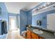 Well-lit bathroom with blue walls, tiled floors, and a combined tub and shower at 5123 Whispering Leaf Trl, Valrico, FL 33596
