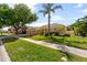 A beautifully landscaped home with a lush green lawn, mature trees, and a well-maintained exterior at 5123 Whispering Leaf Trl, Valrico, FL 33596