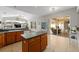 Bright kitchen boasts tile floors, a kitchen island, ample natural light, and a view to the screened patio at 5123 Whispering Leaf Trl, Valrico, FL 33596