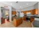 Traditional kitchen features an island, tile floors, light wood cabinets, and stainless steel appliances at 5123 Whispering Leaf Trl, Valrico, FL 33596