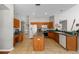An open kitchen features wood cabinets, a center island, and tile flooring at 5123 Whispering Leaf Trl, Valrico, FL 33596