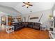 Spacious living room with open layout, kitchen view, wood floors, and comfortable leather seating at 5123 Whispering Leaf Trl, Valrico, FL 33596