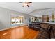 Open living room with leather sofa, hardwood floors, and a view to the backyard at 5123 Whispering Leaf Trl, Valrico, FL 33596