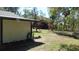 Back yard with patchy grass, open area for pets or gardening, and partial shade from trees at 5425 Leisure St, Dade City, FL 33523