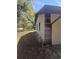 A charming home with a neutral-toned stucco exterior, featuring a brown roof and lush, natural surroundings at 5425 Leisure St, Dade City, FL 33523