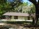 Front exterior of home with a covered porch, level lot, minimal landscaping, and new roof at 5425 Leisure St, Dade City, FL 33523