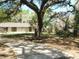 Charming single-story home featuring a large oak tree and a driveway at 5425 Leisure St, Dade City, FL 33523