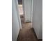 Hallway with neutral carpeting, white walls, and view into room with window and blinds at 5425 Leisure St, Dade City, FL 33523