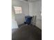 Unfinished storage room with concrete floor, small windows, blue trash can, and old wooden ladder at 5425 Leisure St, Dade City, FL 33523