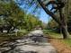 Scenic street view showcasing mature trees lining the roadway and well-maintained neighborhood at 5425 Leisure St, Dade City, FL 33523
