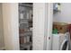 Well-organized pantry shelving next to a laundry machine, maximizing storage and convenience at 5606 Pinnacle Heights Cir # 105, Tampa, FL 33624