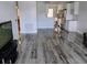 Bright living room boasting stylish gray wood floors adjacent to a kitchen with stainless appliances at 5725 80Th N St # 314, St Petersburg, FL 33709