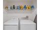 Bright laundry room features a white washer and dryer plus storage shelves at 607 Royal Empress Dr, Ruskin, FL 33570