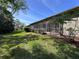 Well-maintained exterior showcasing a covered patio and lush landscaping at 610 S Woodlands Dr, Oldsmar, FL 34677
