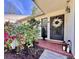 Charming front entrance with brick landing, a decorative wreath, and beautiful bougainvillea at 610 S Woodlands Dr, Oldsmar, FL 34677
