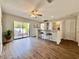 Open-concept living space with hardwood floors, bar seating, and a sliding glass door to the patio at 610 S Woodlands Dr, Oldsmar, FL 34677