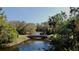 A scenic view of a calm waterway with a pedestrian bridge, surrounded by lush trees at 610 S Woodlands Dr, Oldsmar, FL 34677