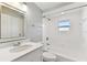 Bathroom with a shower-tub combo, decorative vanity mirror and white cabinets at 6316 S Richard Ave, Tampa, FL 33616