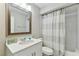 Bathroom vanity with decorative mirror and shower with patterned curtain at 6316 S Richard Ave, Tampa, FL 33616